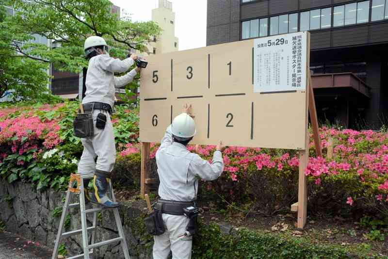 熊本市役所の構内に設置された県議熊本市1区補選の候補者ポスター掲示板＝9日、同市中央区