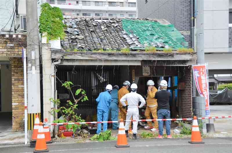 危険な空き家を行政代執行で解体するため現地を確認する作業員ら＝９日午前、熊本市中央区