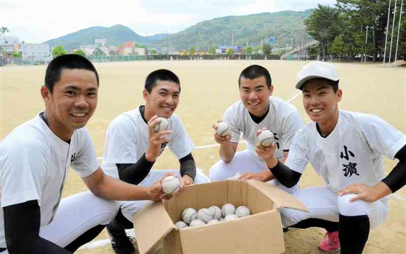元プロ野球選手の山中浩史さんから贈られた公式球を手にする天草工高の野球部員ら＝天草市