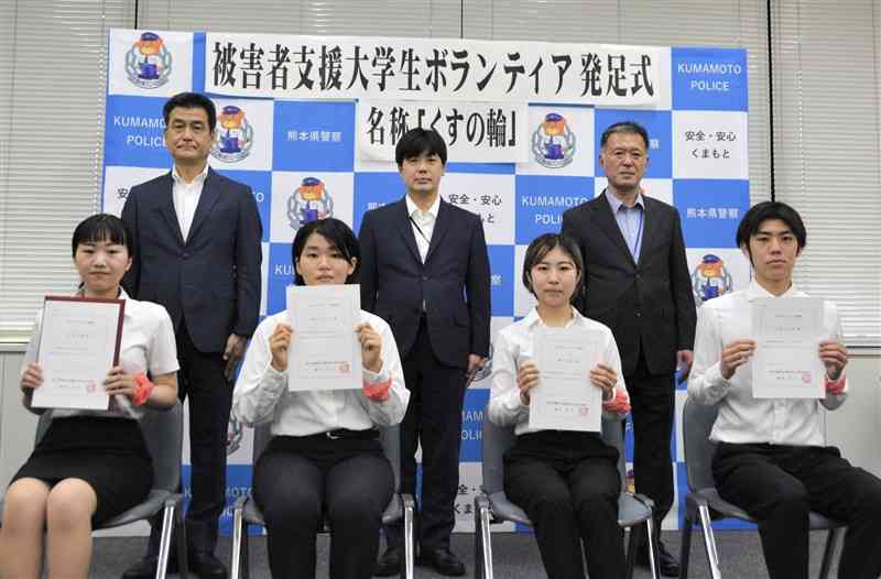 犯罪被害者支援の学生ボランティア組織「くすの輪」の発足式に出席した大学生4人（前列）＝11日、熊本市中央区
