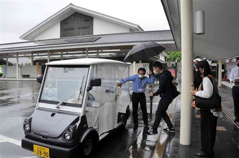 グリーンスローモビリティの実証実験で、カート型電動車に乗り込む利用者＝熊本市中央区