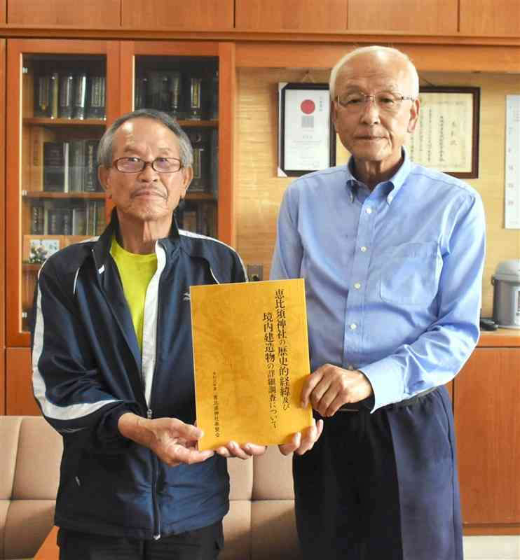 佐藤教育長（右）に冊子を手渡した恵比須神社奉賛会の長田会長＝多良木町