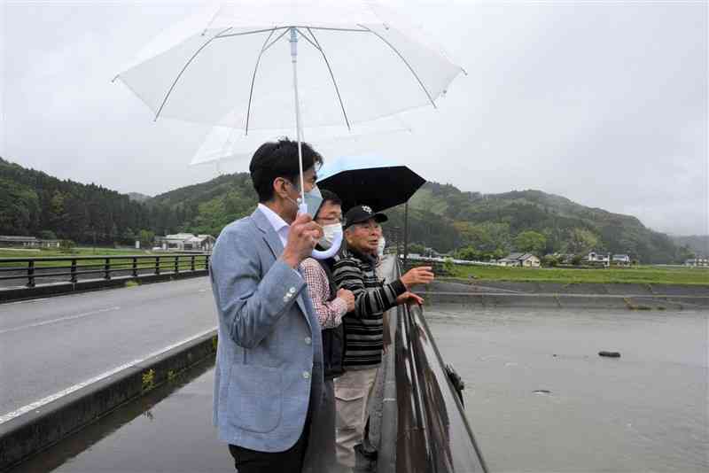 大柿地区に濁流が押し寄せてきた時の様子を県議らに説明する山上修一さん（写真奥）＝13日、人吉市