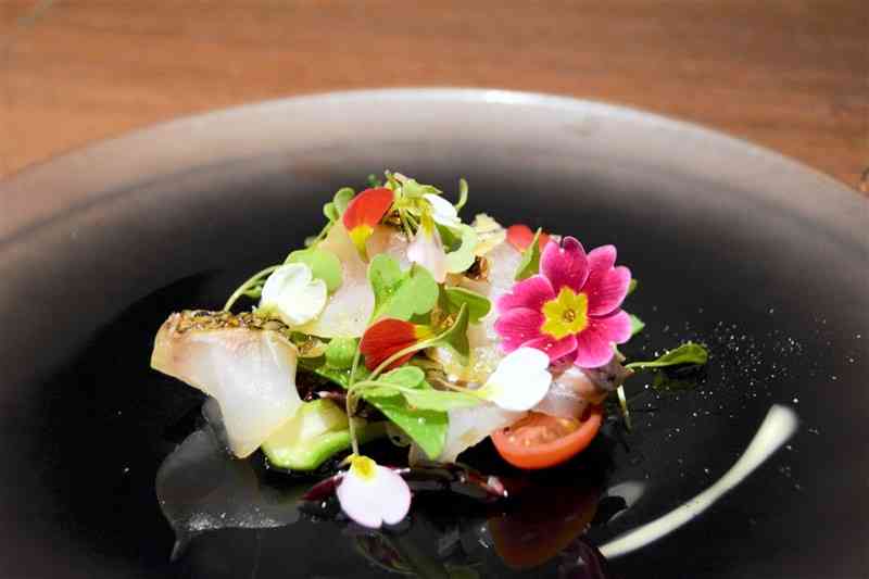 プリムラの花びらをあしらったpopolaの「天草産天然鯛のスモークと野菜のサラダ」