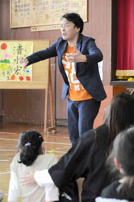 大野小の児童を前に、笑いを交えて仕事や海外経験を語る清水宏さん＝芦北町