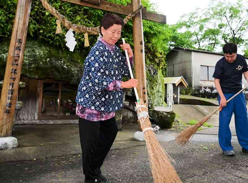 弁財天の清掃を約30年間、毎日続けている山本アヤ子さん。右は長男の章博さん＝宇土市