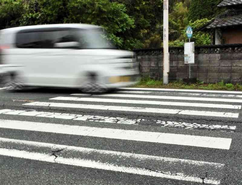 信号機のない横断歩道に重なるように立つ平原バス停（下り）＝熊本市北区