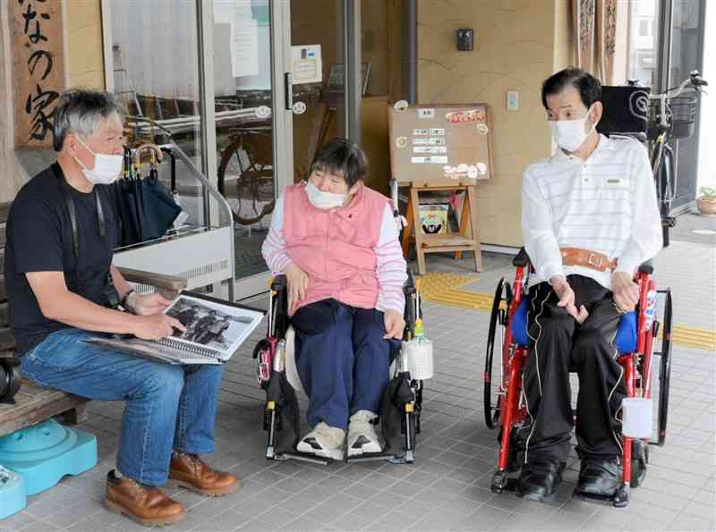 思い出を振り返る胎児性患者の加賀田清子さん（中央）、金子雄二さん（右）、写真家の石川武志さん＝4月26日、水俣市