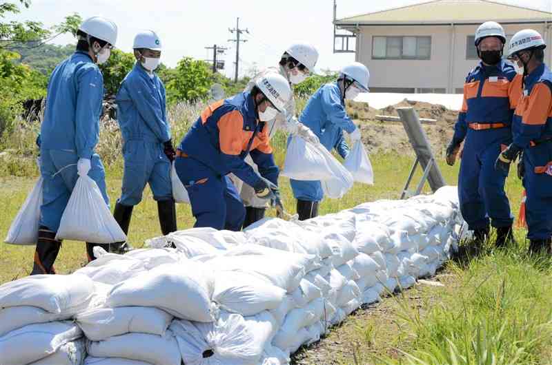 水防訓練で土のうを積み上げる消防隊員と市職員ら＝熊本市西区