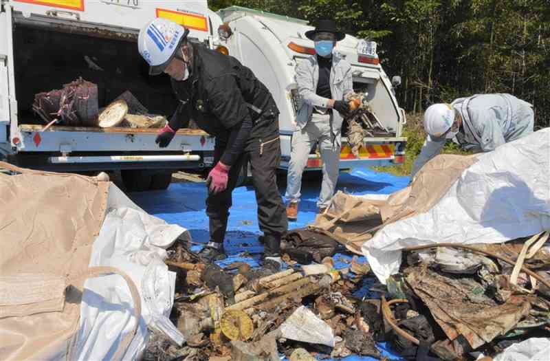 不法投棄された廃棄物を分別する解体工事業者ら＝熊本市西区