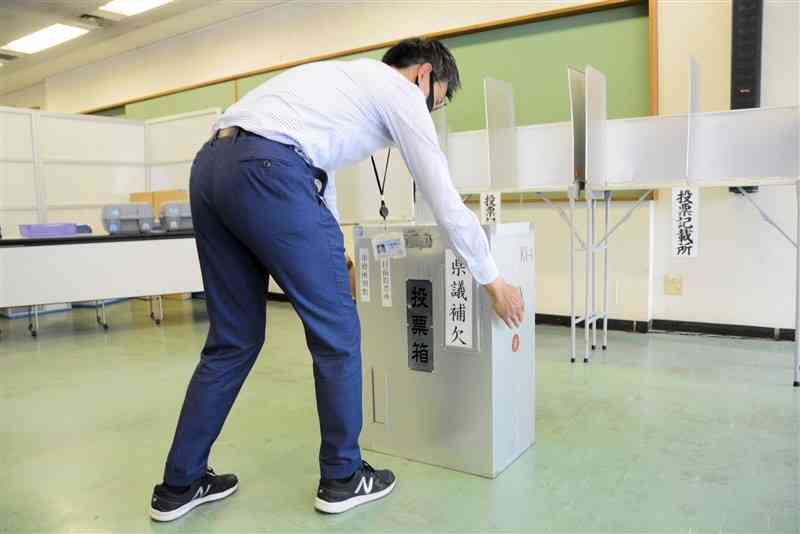 熊本市役所別館自転車駐車場に期日前投票所を設営する市職員＝19日、同市中央区