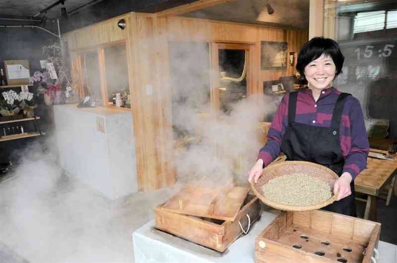地中から噴出する蒸気でコーヒー豆を蒸す山本美奈子さん＝小国町