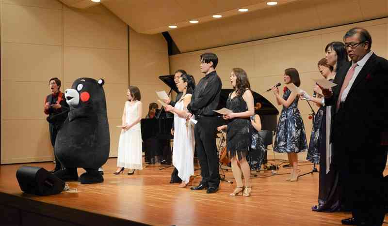 熊本復興支援チャリティーコンサートのフィナーレで、くまモンも交えて「ふるさと」を歌う出演者ら＝21日、東京・新宿区
