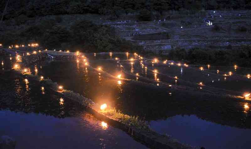 竹のあかりで彩られ、幻想的な光景が浮かび上がった寒川地区の棚田＝水俣市