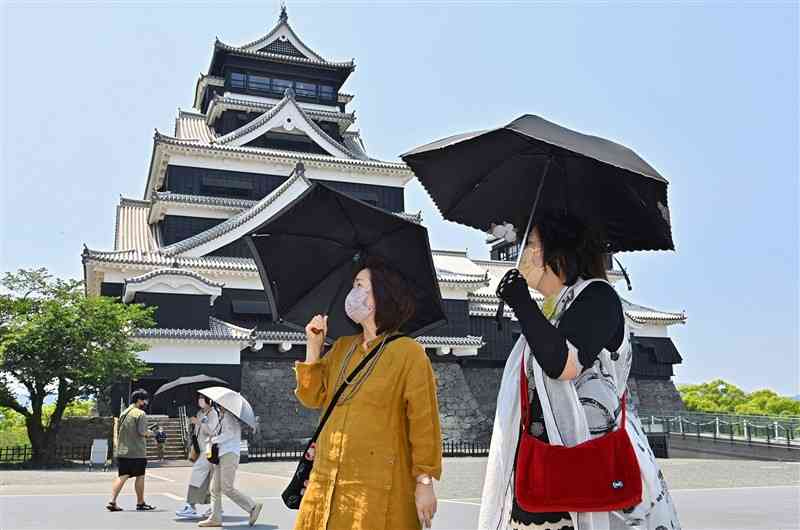 日傘を差して熊本城内を歩く観光客ら＝24日午後、熊本市中央区（後藤仁孝）