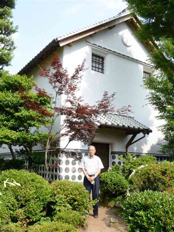 修復工事が終わった「中の蔵」の前に立つ11代当主の江藤武紀さん＝大津町