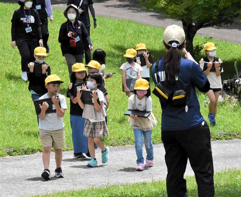 合同授業で、タブレット端末を持ち、撮影場所に向かう児童たち＝水上村