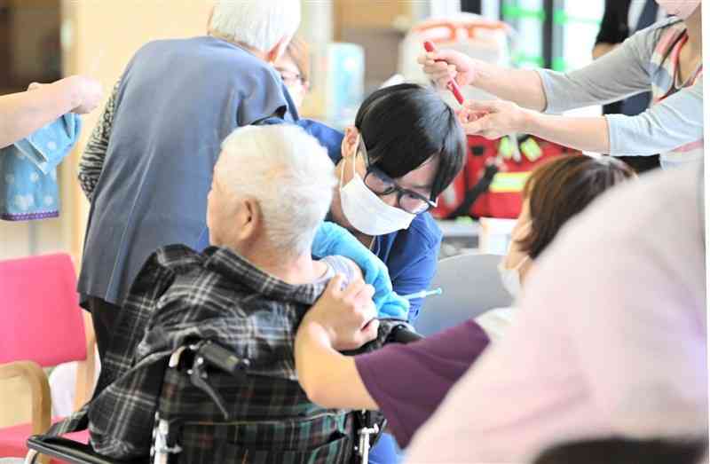 特別養護老人ホーム「あそん里」の入所者にワクチンを打つ看護師ら＝30日午前、阿蘇市