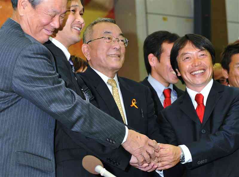 J2参入決定の報告を受け笑顔で握手する筆者（右から2人目）ら