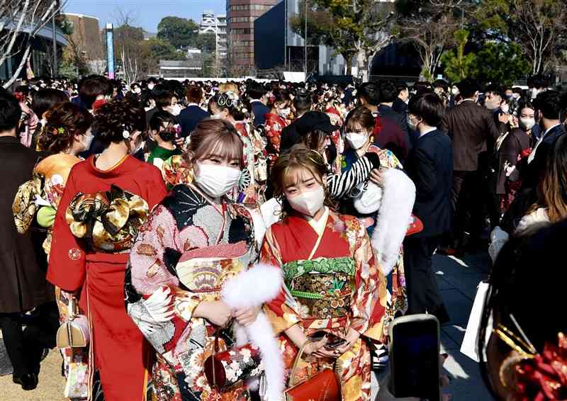 今年の成人式の会場前で、友人らと記念撮影する新成人たち＝1月10日、熊本市中央区（石本智）