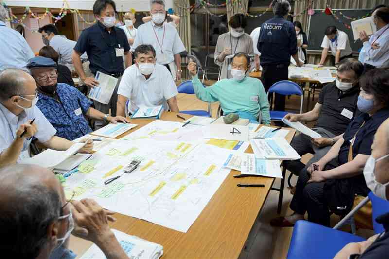 集団移転先の候補地について市の説明を受け、意見を出し合う大柿地区の住民＝5月31日、人吉市