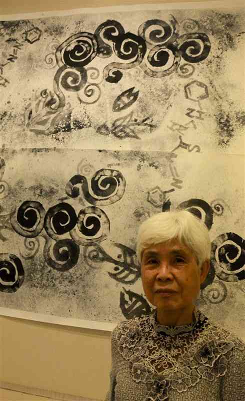 「汚された海」と題した自作の墨絵と西元利子さん＝5月30日、東京・銀座