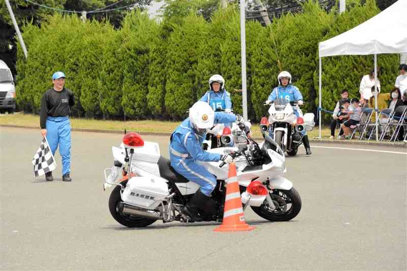 巧みなスラローム走行を披露する白バイ隊員＝熊本市北区