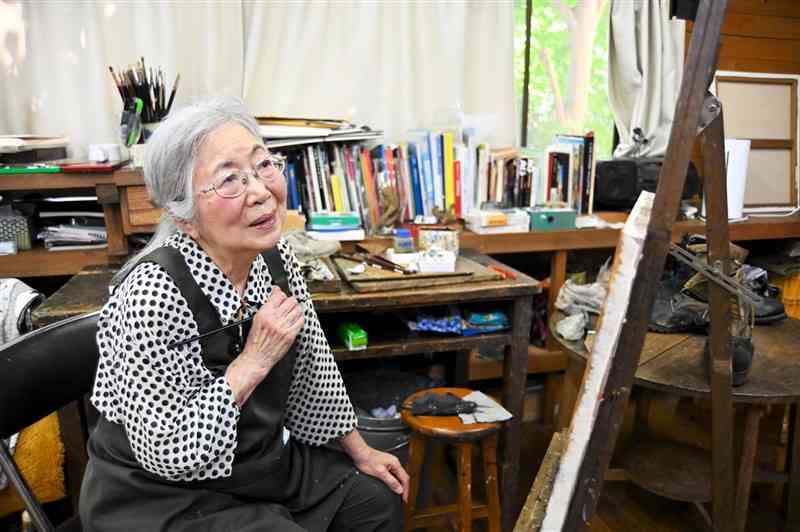 アトリエで絵筆を握る渕田安子さん。時間を惜しまず作品に向き合い、2年近くかけて仕上げていく＝合志市