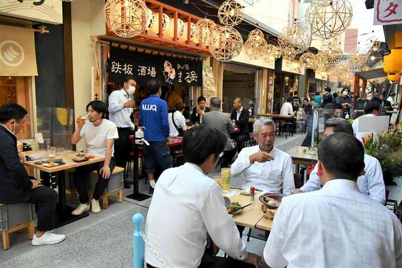 3日オープンする「熊本屋台村」で、料理や県産酒を堪能する内覧会の来場者たち＝2日、熊本市中央区