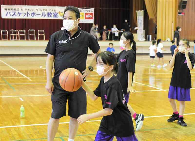 小学生の練習を見守る梅嵜英毅さん＝荒尾市