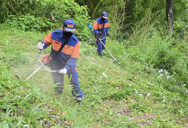 草刈りに精を出す参加者＝菊池市