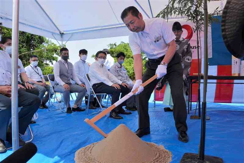 相良村の災害公営住宅の安全祈願祭で、くわ入れする吉松啓一村長＝同村