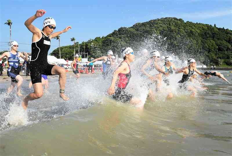 波の高い海へ向かって一斉にスタートするエリート女子の選手たち＝天草市（坂本明彦）