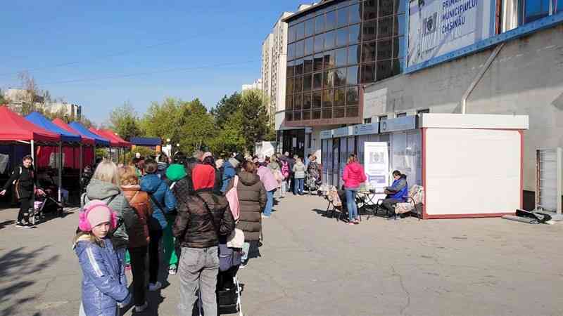 食料の配給に並ぶウクライナ避難民。右の白い建物が仮設診療所＝4月19日、モルドバ（江川孝教授提供）