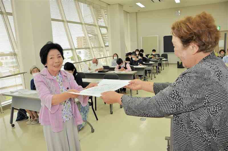 熊日潮さゐ短歌大会で天賞を受賞した守住孝子さん（左）＝八代市