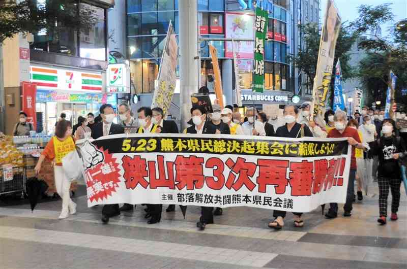 石川一雄さんの無実を訴え、アーケード街をデモ行進する集会の参加者たち＝13日、熊本市中央区