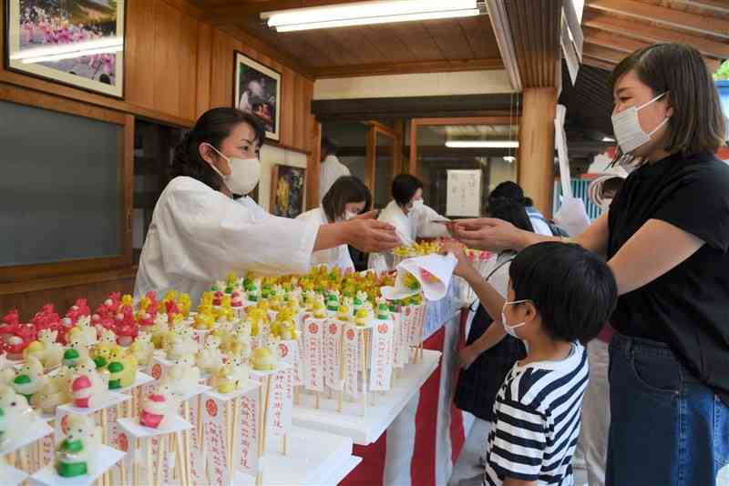 八坂神社の祇園祭「犬子ひょうたん」で、愛らしい子犬をかたどった縁起物を買い求める参拝客ら＝山鹿市