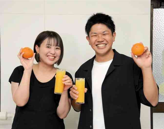 規格外の甘夏でコールドプレスジュースを作る桑原健太さん（右）と妻の茜さん＝八代市