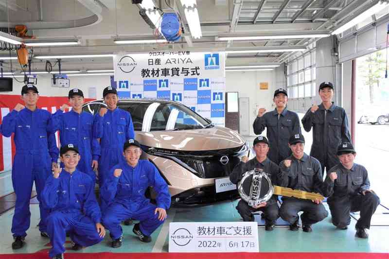 日産自動車が開新高に貸与した「新型アリア」と自動車科の生徒ら＝熊本市中央区