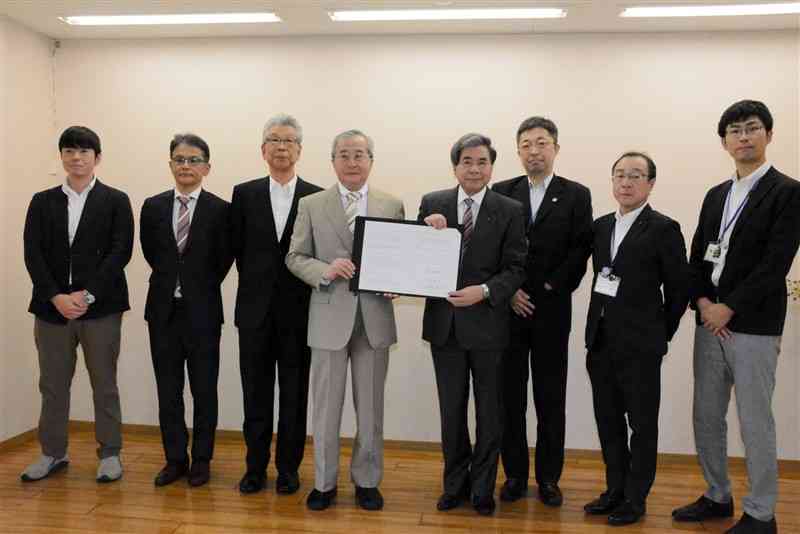 障害者の就労を支援する連携協定を結んだ日本財団の尾形武寿理事長（左から4人目）と蒲島郁夫知事（同5人目）＝熊本市西区