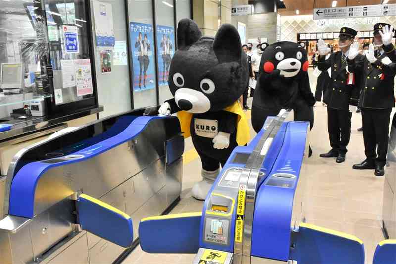 自動改札機にICカードをかざすJR九州のキャラクターくろちゃん＝25日、熊本市西区のJR熊本駅