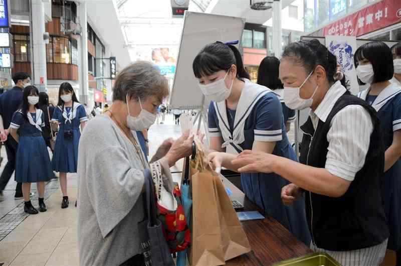 廃棄予定の食材を使用したスイーツを販売する熊本学園大付属高生ら＝熊本市中央区