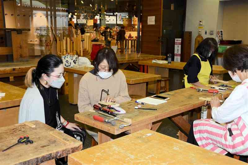 伊藤恵美子さん（左）指導の下、肥後象がん作りに挑戦する参加者＝熊本市中央区