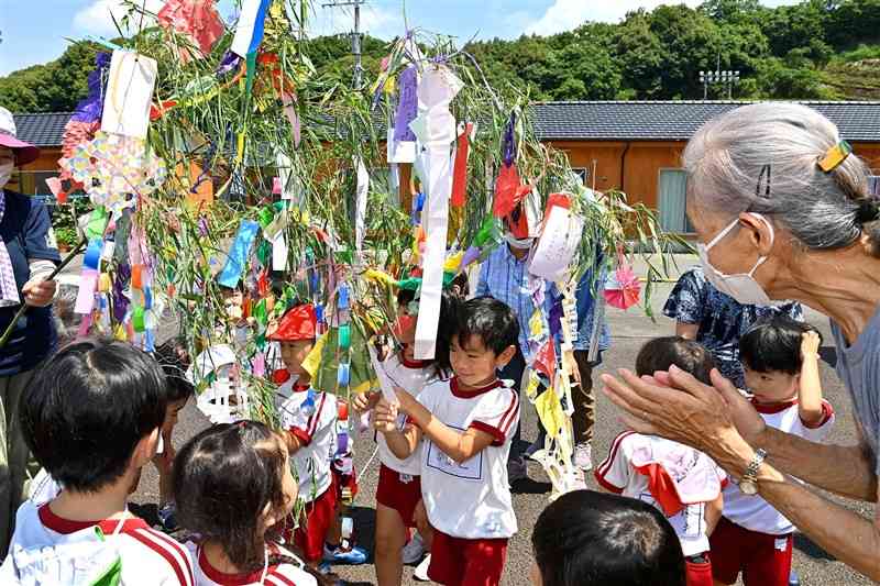 仮設団地の住民らと七夕の飾り付けを楽しむ渡保育園の園児たち＝27日、球磨村