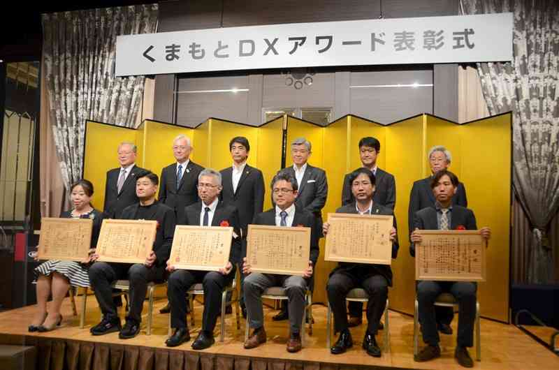 「くまもとDX大賞」を受賞したワイズ・リーディングの中山善晴社長（前列左から4人目）ら＝27日、熊本市中央区