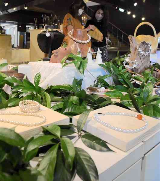 植物で飾ったコーナーに淡水真珠のネックレスなどが並ぶ「真珠と陶」＝熊本市中央区