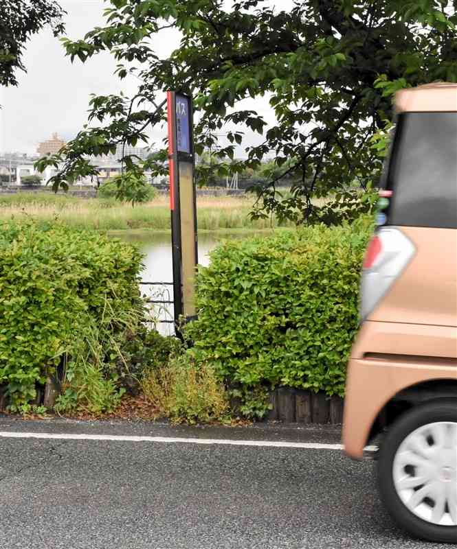かつての烏ケ江バス停。歩道もなく、植栽のすき間のバス待ちスペースは、わずか半畳ほどだった＝5月中旬、熊本市東区
