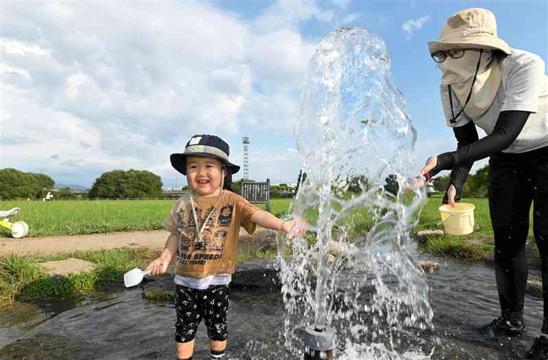 水前寺江津湖公園の噴水で水遊びをする子ども＝30日午後5時5分ごろ、熊本市東区（石本智）