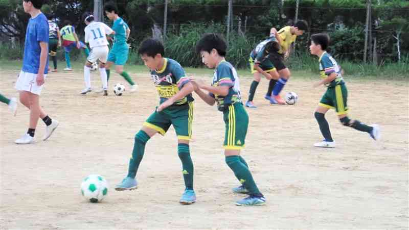 練習でボールを奪い合うFKアドリア水俣の選手たち。今夏に初の東欧遠征に挑む＝津奈木町