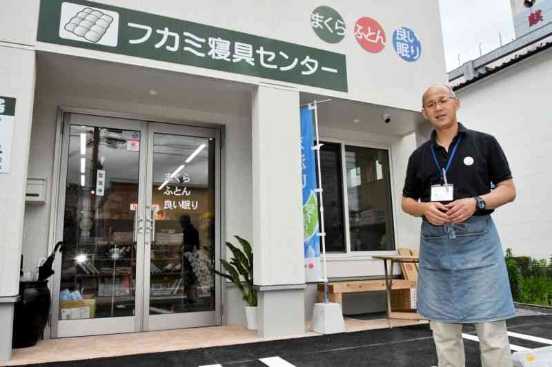 再建した店舗を前に「商売をもう一度立て直す」と語る深水克昭さん＝6月22日、人吉市紺屋町